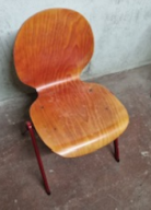 Photo détaillant le don chaises bois et pieds métal rouge